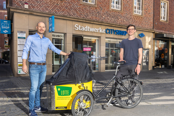 Das kostenlose Lastenrad Lotte kann bis Ende Juli im CityShop der Stadtwerke ausgeliehen werden. Darüber freuen sich Steffen Schmidt von der Lastenrad-Initiative „Lasse“ (r.) und CityShop-Leiter Marcel Braulik.