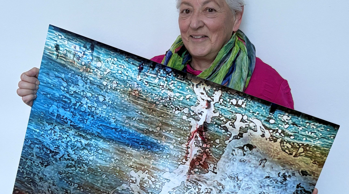 Eine Frau hällt ihr Kunstwerk in den Händen.