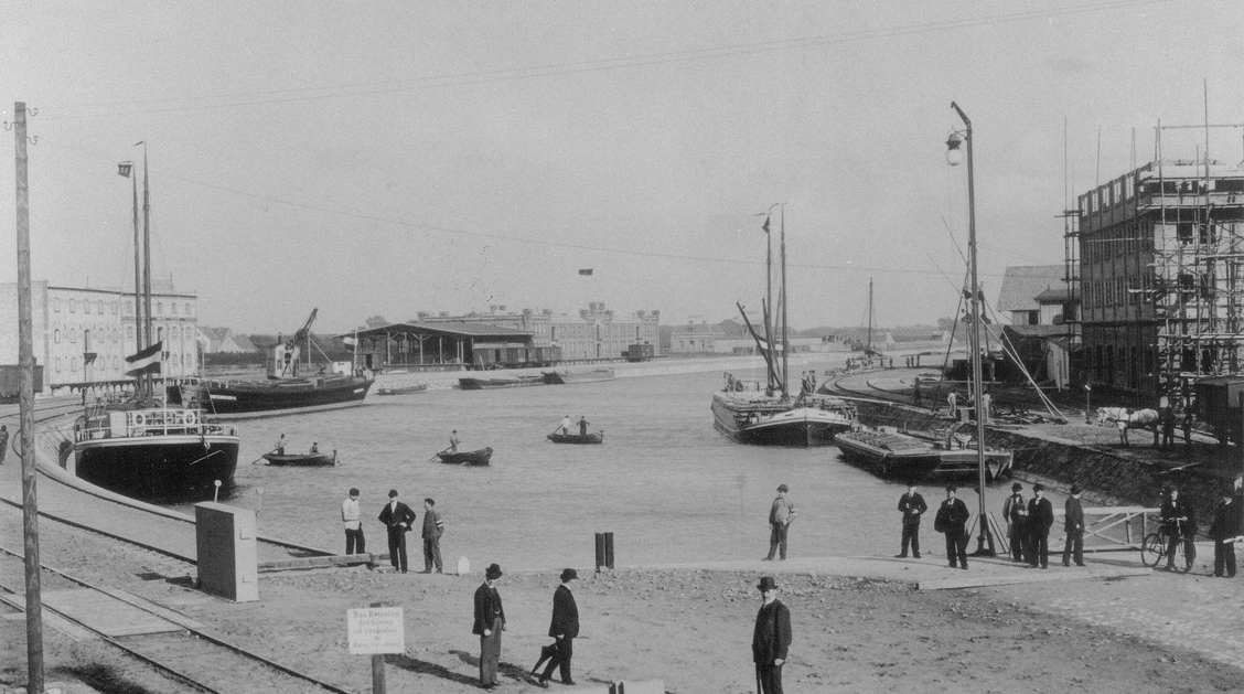 Der Hafen von Münster kurz nach der Fertigstellung, es liegen Schiffe im Wasser, Menschen sind zu erkennen