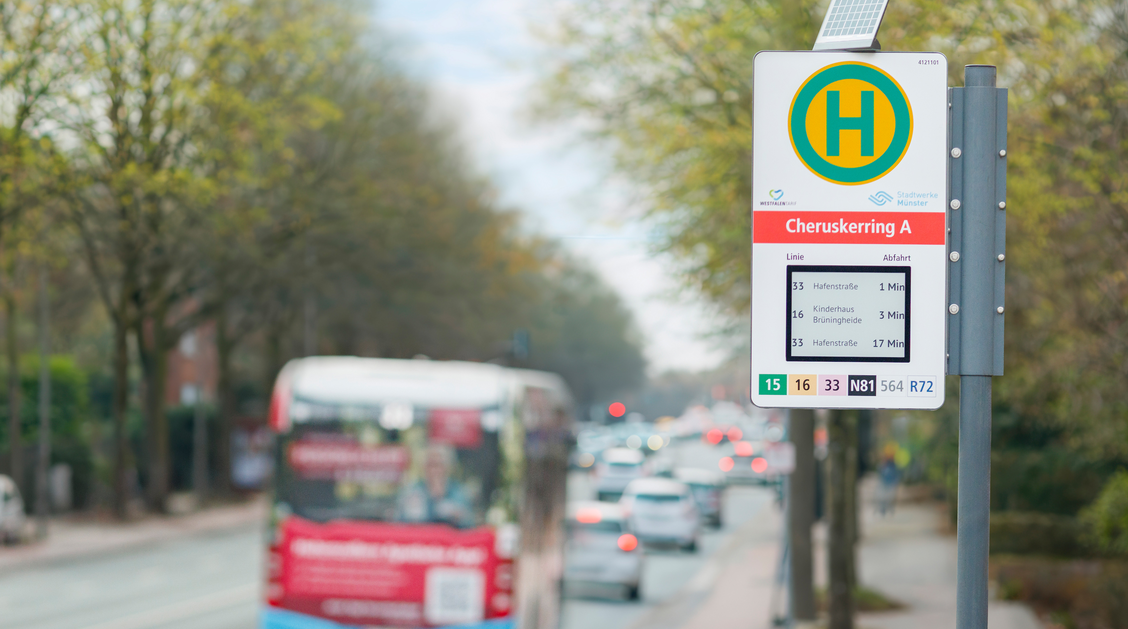 Eine Haltestelle mit digitaler Abfahrtstafel, im Hintergrund ein Bus und Autos | © LUMINO Licht Elektronik GmbH