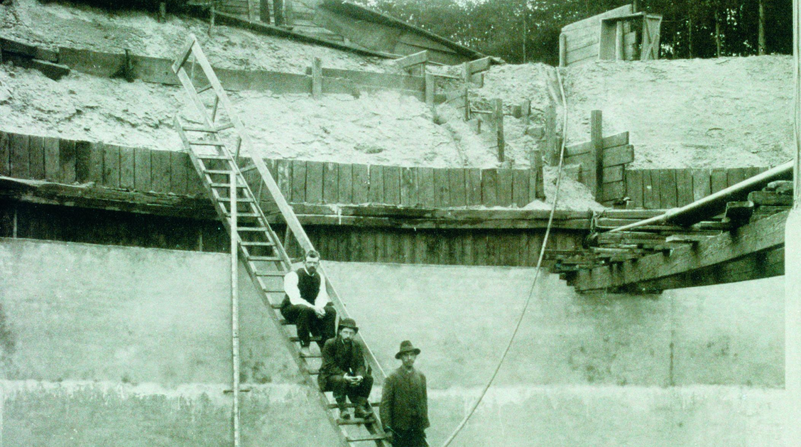 Eine tiefe Baugrube mit mehreren Bauarbeitern auf einer Treppe