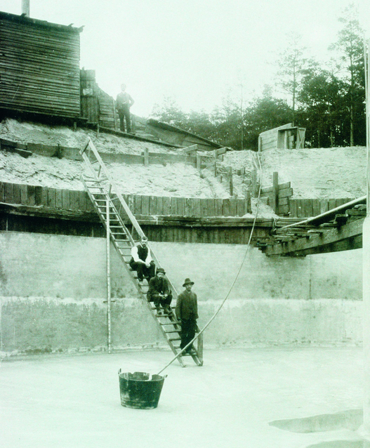 Eine tiefe Baugrube mit mehreren Bauarbeitern auf einer Treppe