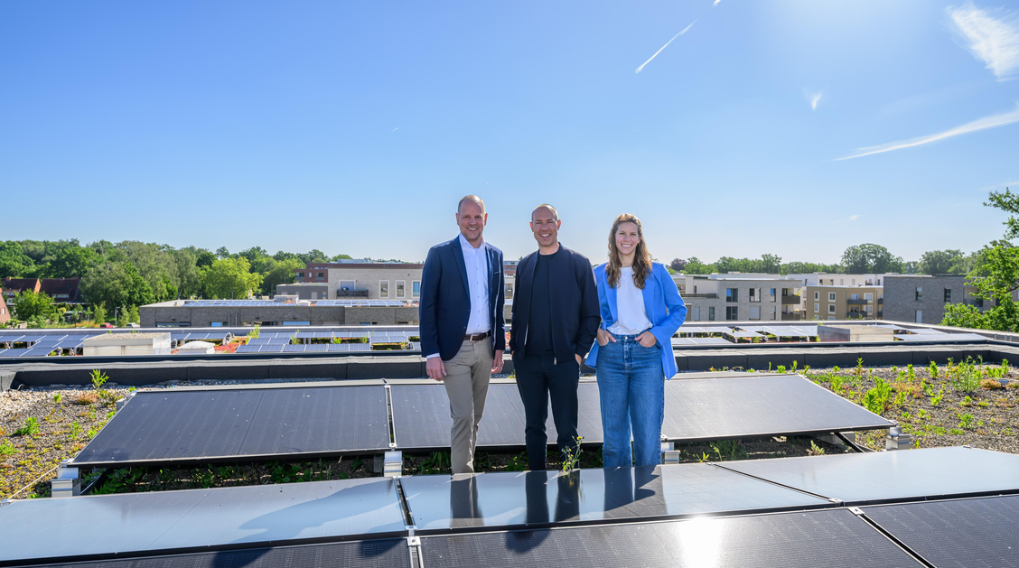 3 Menschen stehen auf einem Dach mit einer Solaranlage