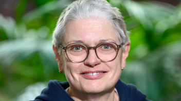 Christiane Puhe steht vor Büropflanzen und schaut freundlich in die Kamera.