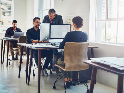 Mehrere Menschen arbeiten an einem Arbeitsplatz am Computer,