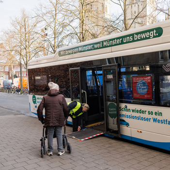 Eine Frau mit Rollator steigt in einen Stadtwerke-Bus ein.