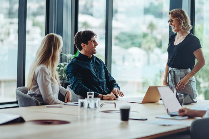 Fünf Personen sitzen um einen Konferenztisch.