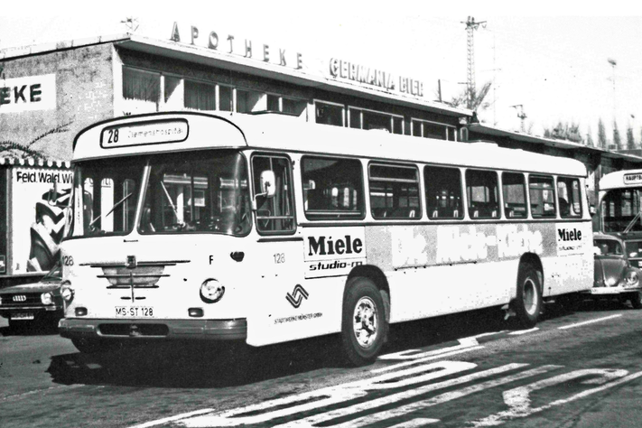 Ein Bus der Linie 28 steht auf einer Straße, dahinter ein Auto
