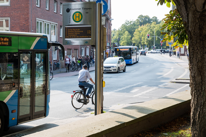 Ein Bus steht an einer Haltestelle mit elektronischem Abfahrtsdisplay