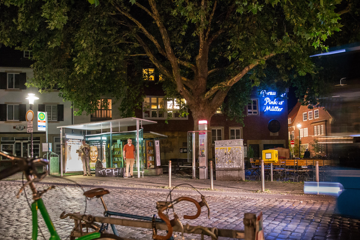 Ein Nachtbild der Haltestelle Kuhviertel, im Hintergrund befindet sich Leuchtreklame