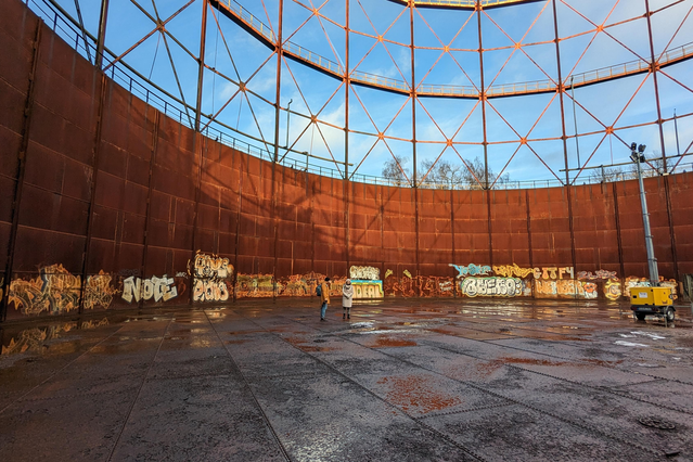 Ein alter Gasometer von Innen, zu sehen sind Stahlboden und -wände sowie ein Stahlgerüst