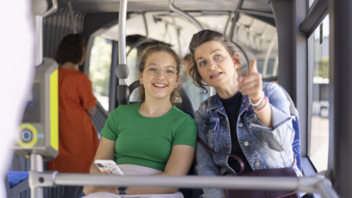 Ein Mädchen sitzt mit ihrer Mutter im Bus.