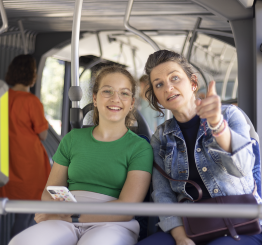 Ein Mädchen sitzt mit ihrer Mutter im Bus.