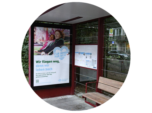 In einer Bushaltestelle hängt Werbung der Stadtwerke Münster.