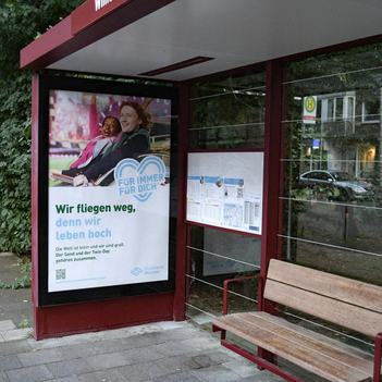 In einer Bushaltestelle hängt Werbung der Stadtwerke Münster.