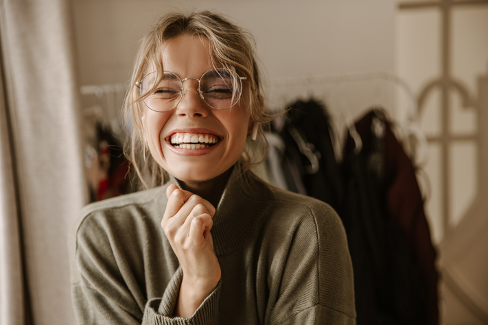 Eine lächelnde junge Frau mit Brille.