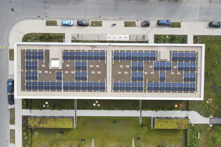 Ansicht von oben auf ein Gebäude mit Photovoltaikpaneelen.