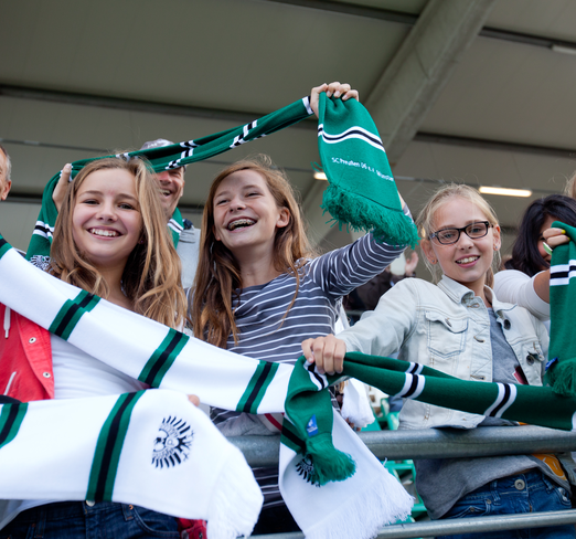 Junge Fans von Preußen Münster jubeln auf der Tribüne.