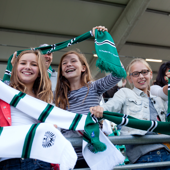 Junge Fans von Preußen Münster jubeln auf der Tribüne.