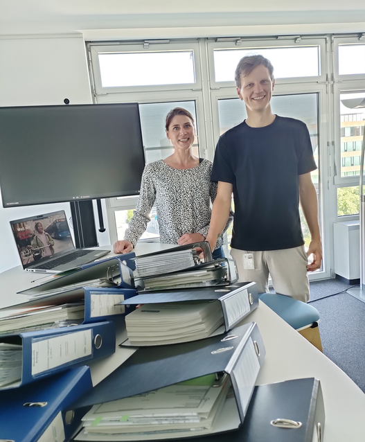Ein dicker Stapel Aktenordner zeugt von vielen Monaten Arbeit: Die Projektentwickelnden Janine Rose und Philipp Richter von den Stadtwerken Münster haben den Antrag für drei Anlagen in Dülmen-Hangenau eingereicht.