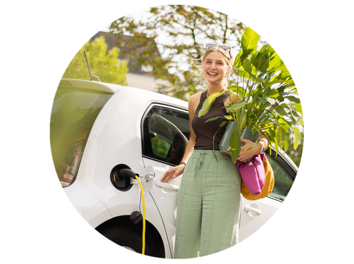 Ein junge Frau steht mit einer Pflanze vor einem Carsharing-Auto.