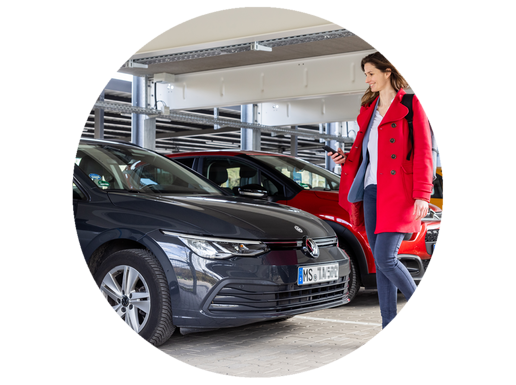 Eine Frau läuft im Parkhaus zu einem Auto.