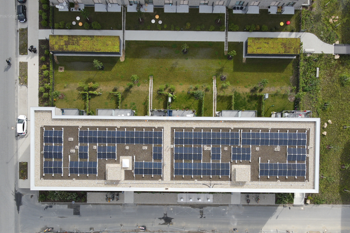 Ansicht von oben auf ein Gebäude mit Photovoltaikpaneelen.