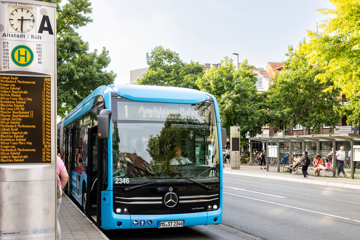 Bus hält an einer Bushaltestelle.
