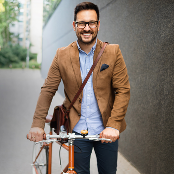 Junger Mann schiebt ein Fahrrad.