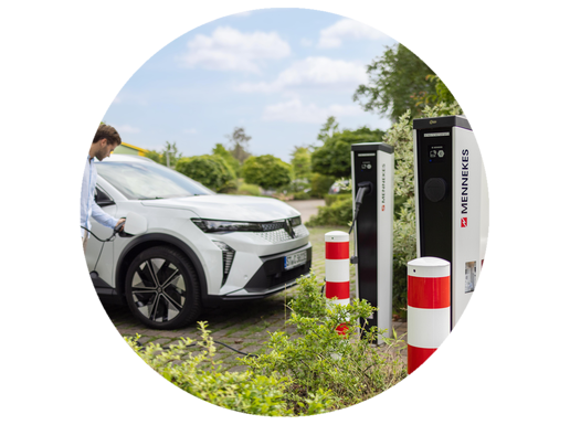 Ein Mann im Hemd tankt sein weißes E-Auto hinter zwei E-Ladesäulen von Mennekes.