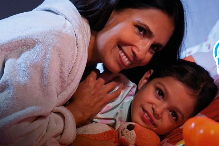 Eine Mutter kuschelt mit ihrer Tochter im Bett.