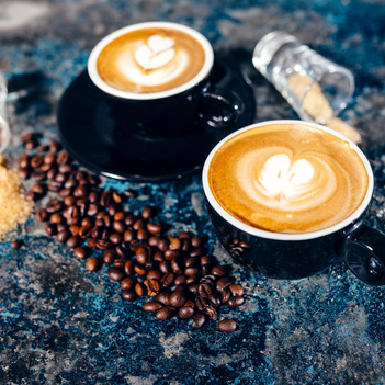 Zwei Tassen Capuccino mit Herzen aus Milchschaum.