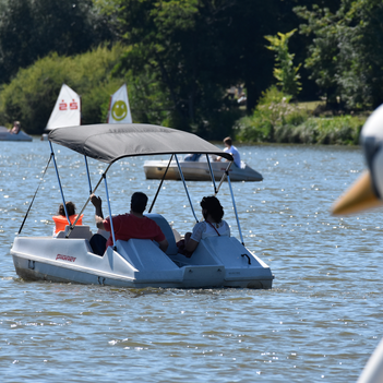 Ein Tretboot mit einer Gruppe Menschen auf einem See
