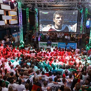 Viele Menschen schauen gemeinsam ein Fußballspiel an.