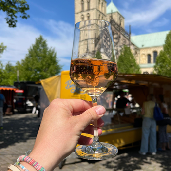 Weinglas in der Hand auf dem Wochenmarkt