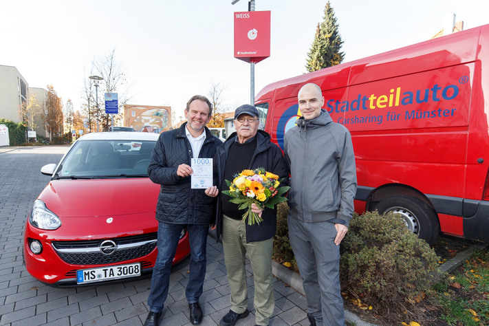 Joachim Hesemann (Mitte) freut sich als 1000. CarSharer mit PlusCard über einen Fahrtgutschein aus den Händen von Stefan Grützmacher (l.) und Till Ammann.