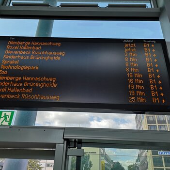 Die Stadtwerke haben die großen Anzeigen für die nächsten Busabfahrten im Empfangsgebäude des Hauptbahnhofs verbessert. Pro Bildschirm wird nun ein Bussteig angezeigt, hier B1. Die Pfeile weisen die Richtung zu den Bussen.