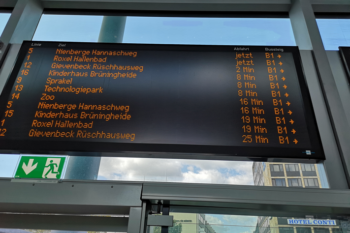 Die Stadtwerke haben die großen Anzeigen für die nächsten Busabfahrten im Empfangsgebäude des Hauptbahnhofs verbessert. Pro Bildschirm wird nun ein Bussteig angezeigt, hier B1. Die Pfeile weisen die Richtung zu den Bussen.