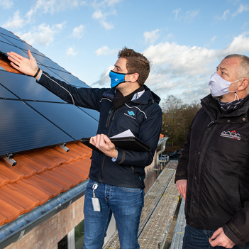 Bevor das Baugerüst entfernt wird, schauten sich Frederik Stroetmann (Stadtwerke Münster) und Andreas Jenschke (Wohn + Stadtbau) die neuen Photovoltaik-Anlagen an der Von-Stauffenberg-Straße noch einmal aus der Nähe an.