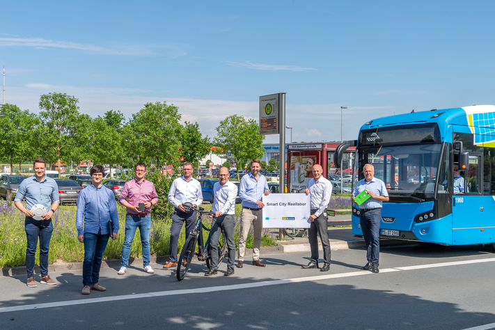 Rüsten den Parkplatz Nieberdingstraße zum Smart-City-Reallabor auf: Robin Denstorff, Stadtbaurat und Frank Gäfgen, Geschäftsführer Stadtwerke Münster (dritter und zweiter von rechts) mit dem gemeinsamen Projektteam von Stadt und Stadtwerken: Fabian Röttgering, Dr. Thomas Terstiege, Stefan Kohake, Peter Knoll, Dr. André Wolf und Andreas Pott (v. l.).