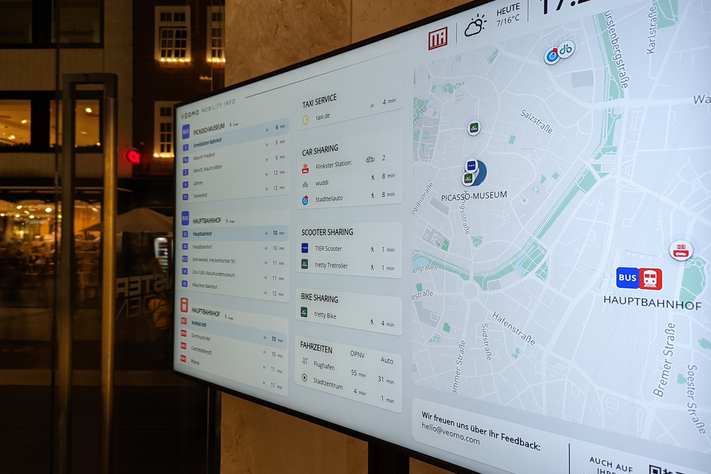 Das Mobilitätsdisplay in den Münster-Arkaden zeigt die nächsten Bushaltestellen, Car-sharing-Stationen, E-Scooter und mehr an. Elektronischer Bildschirm, der die nächsten Bushaltestellen anzeigt.