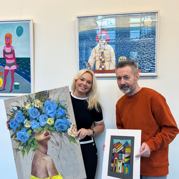 Ein Mann und eine Frau halten Kunstwerke in der Hand.