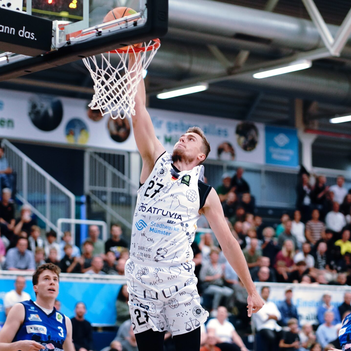Ein Basketballspieler wirft einen Korb.