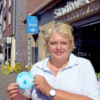 CityShop-Leiterin Christiane Puhe mit dem Refill-Münster-Zeichen.