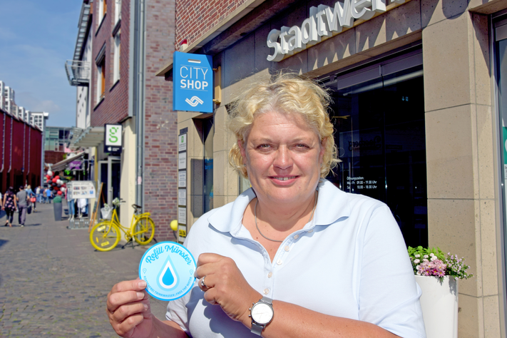 CityShop-Leiterin Christiane Puhe mit dem Refill-Münster-Zeichen.